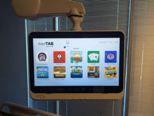 Modern patient entertainment system mounted on a swingarm TV in a healthcare facility in San Antonio. 