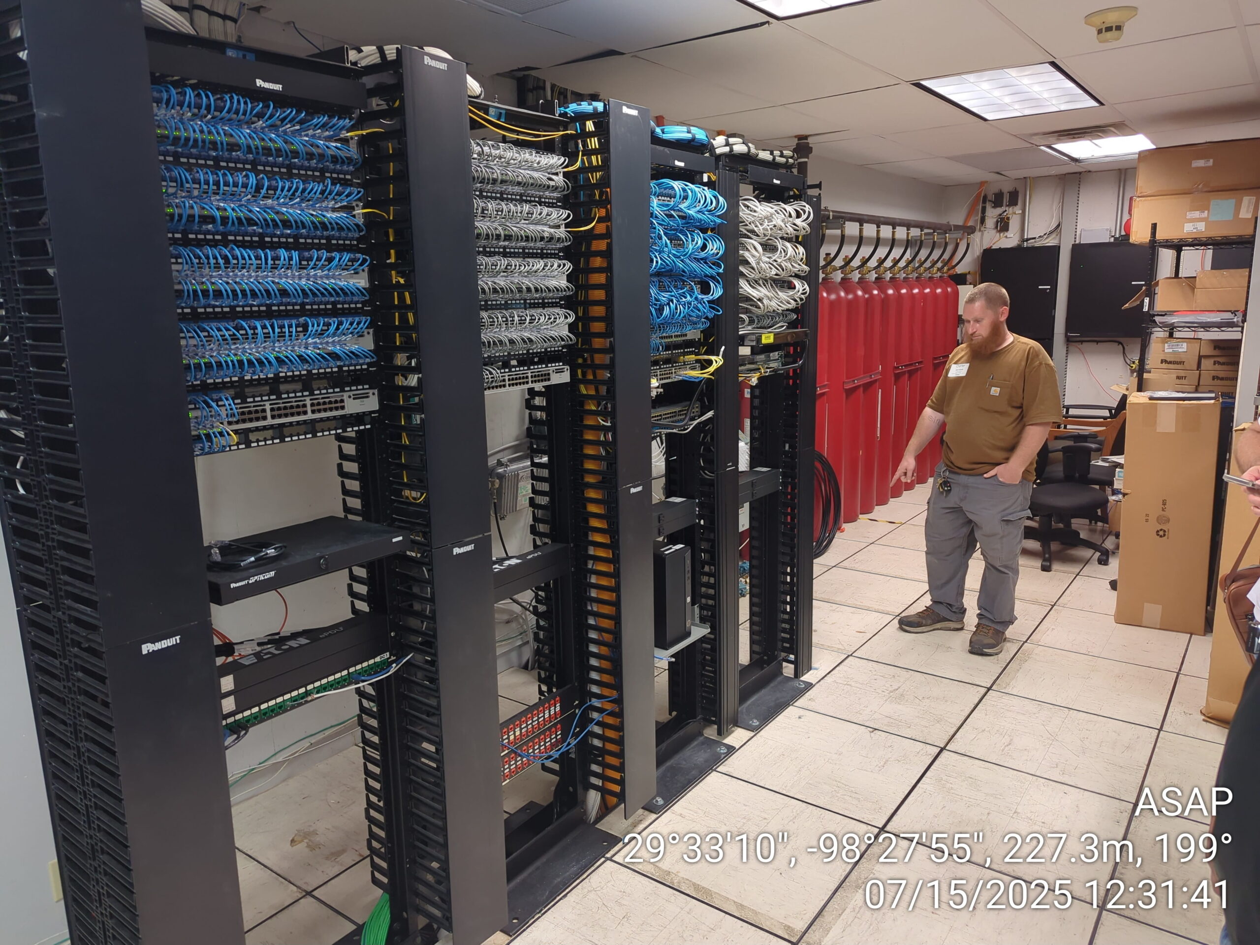 ASAP Computer Services technician managing physical data center infrastructure, patch panels, and server racks during an on-site network support dispatch in San Antonio.