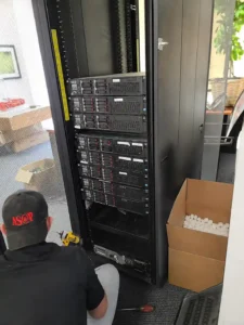 ASAP Computer Services technician de-racking HP ProLiant servers from a cabinet during a commercial IT relocation in San Antonio